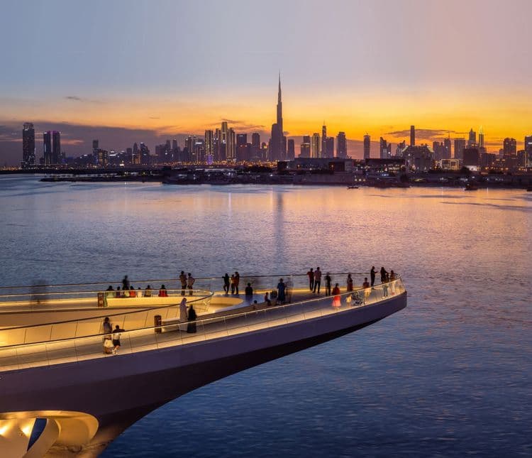 Dubai Creek Harbour waterfront promenade with the Dubai skyline at sunset